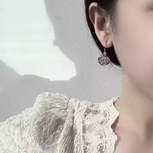 Elegant silver flower knot circle earrings with zircons shown on a model