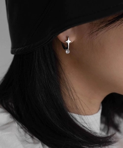 Close-up of minimalist silver star earring with round zircon on female model's ear