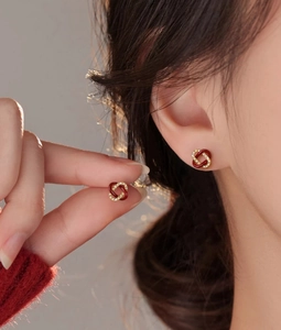 Gros plan de boucles d'oreilles nœud en émail rouge avec zircons et dorure chic