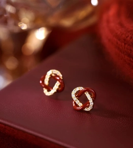 Vue macro de boucles d'oreilles nœud avec émail rouge et micro-pavage de zircons