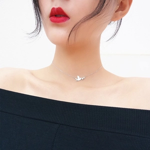 Détail du pendentif oiseau et étoile sur chaîne en argent portée par le mannequin