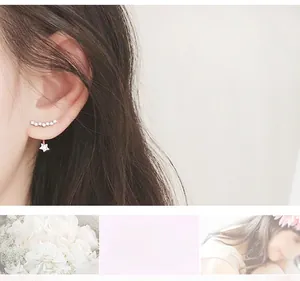 Detail of star-shaped stud earrings with curved crystal accents and hanging star charm