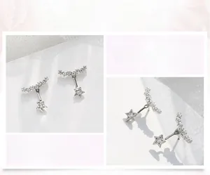 Macro detail of star-shaped silver stud earrings with hanging stars and sparkling crystals
