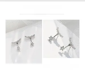 Macro shot of silver star stud earrings with sparkling crystals and curved diamond row