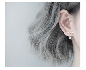 Close-up of star-shaped ear crawler and stud earrings set with sparkling cubic zirconia