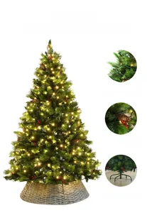 Close-up of PVC Christmas tree needles with warm LED lights and red berry accents