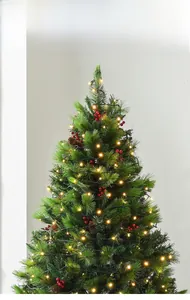 Detail showing dense Christmas tree branches with warm LED lights, pine cones and red berries