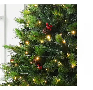 Close-up of dense artificial Christmas tree with pine cones, red berries and LED lights