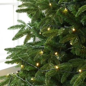 Sapin de Noël vert luxuriant avec guirlandes LED blanc chaud et aiguilles réalistes