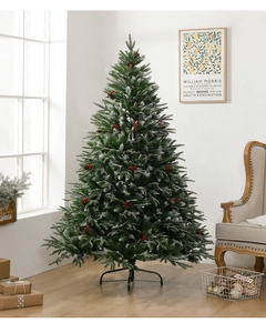 Detail of flocked Christmas tree with red berries, pine cones and metal stand base