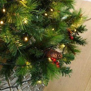 Artificial Christmas tree with pine needles, LED lights, pine cones, and woven basket base