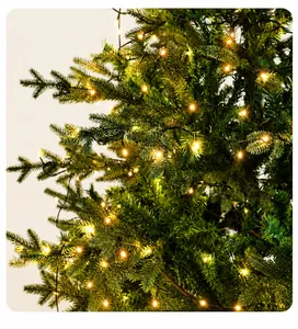 Detail of lush PE needles on a 1.8m Christmas tree with warm glowing LED string lights