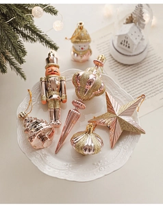 Detailed view of rose gold Christmas ornaments including stars and nutcrackers on a tray
