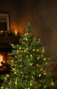 Close-up of 1.8m deluxe PE pine tree with dense needles and warm white LED lights