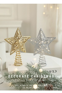 Close-up of gold and silver glittery iron star tree toppers with warm LED lights
