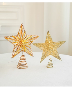 Close-up of golden and bronze Christmas tree toppers with LED wires and metal spiral base