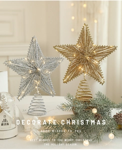 Close-up of gold and silver glittered Christmas tree star toppers with warm LED lights