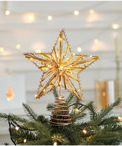 Detail of golden glitter Christmas tree topper star with warm LED lights and spring base
