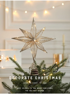 Close-up of golden hollow star tree topper with warm LED lights and glitter finish