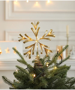 Golden glitter snowflake tree topper with warm LED lights on a decorated Christmas tree