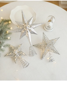 Detailed view of silver glittering star tree toppers with warm LED string lights