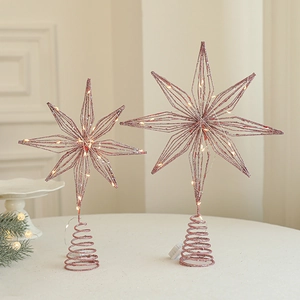 Lighted rose gold iron Christmas tree topper star with warm LED lights and spring base