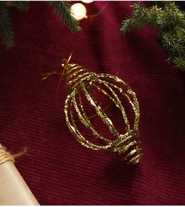 Detail van de gouden glitterende holle spiraal kerstbal op een rode achtergrond