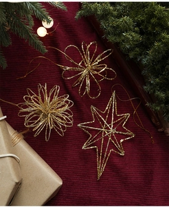 Detailopname van gouden glitter kerstversieringen op een donkerrode fluwelen achtergrond