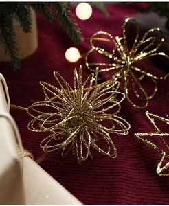Detailopname van gouden glitter kerstversieringen op een rode gebreide ondergrond
