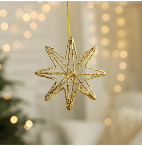 Gedetailleerd zicht op een holle gouden glitterster aan een feestelijke kerstboom