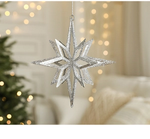Detail van een zilveren glitterster met lovertjes hangend aan de kerstboomtak