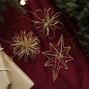Drie gouden glitter ijzeren kersthangers op rode feestelijke stof voor de kerstboom