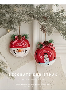 Festive Santa and Snowman iron bells hanging on a Christmas tree with pine cones