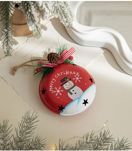 Macro view of red snowman Christmas bell with pine needles and bow tree decoration