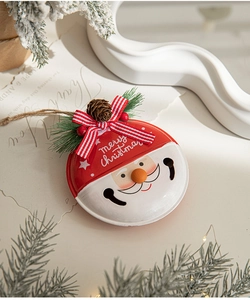 Detailed view of red Santa Claus metal bell with pine cones and merry christmas text