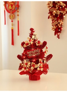 Close-up of red festive lucky tree with golden ornaments and LED lights for New Year