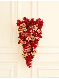 Detail of red New Year swag with golden flowers and festive greeting cards on a white door