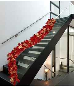 Close-up of red festive garland with gold Fu pendants and LED lights on stairs