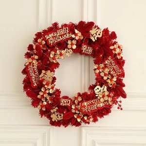 Red festive artificial wreath with golden flowers, red berries and warm LED light string