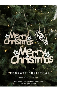 Close-up of wooden Merry Christmas tree ornament with white stars on a festive pine branch