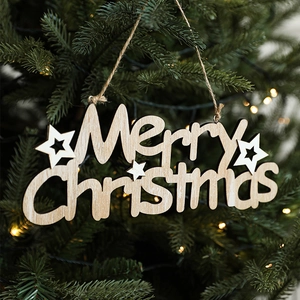 Hollow-out wooden Merry Christmas ornament hanging on tree with warm lights