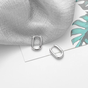 Vue macro détaillée des boucles d'oreilles ovales en argent S925 sur fond minimaliste