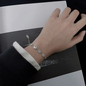 Macro detail of S925 sterling silver smiley face link bracelet with lobster clasp