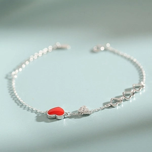 Women's silver heart bracelet featuring red enamel and sparkling cubic zirconia charms