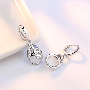 Silver drop earrings featuring moonstone cat-eye stone and hollow engraved patterns