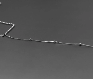 Close-up of a silver satellite chain with delicate bead details and polished finish