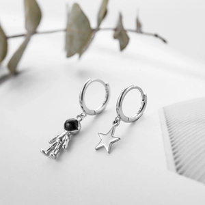 Vue détaillée des boucles d'oreilles asymétriques en argent S925 astronaute et étoile