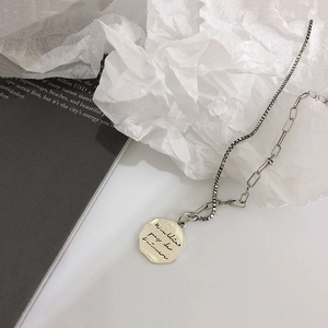 Detail of s925 silver necklace with asymmetrical chain and engraved octagonal pendant