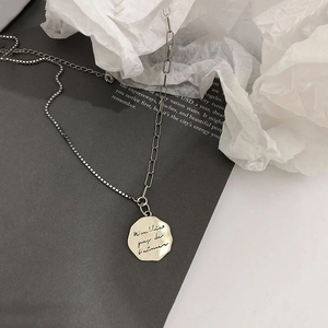 Close-up of retro S925 silver necklace featuring asymmetric chain and octagonal letter charm