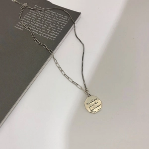 Detail of silver S925 asymmetric paperclip and box chain with irregular round pendant